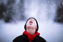 Retrato de menino pegando queda de neve na língua — Fotografia de Stock