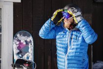 Retrato de snowboarder ajustando óculos de esqui — Fotografia de Stock