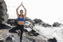 Giovane donna che pratica Yoga sulla spiaggia — Foto stock