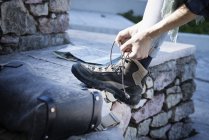 Immagine ritagliata di donna che lega lacci da scarpe su scarpone da passeggio — Foto stock