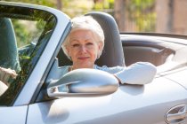 Portrait of senior woman in convertible car — Stock Photo