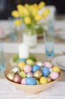 Ciotola di uova di Pasqua colorate in ciotola sul tavolo da pranzo — Foto stock
