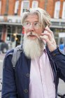 Зрілий чоловік використовує смартфон на відкритому повітрі — стокове фото