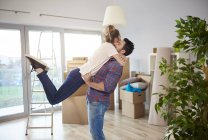 Junges Paar umarmt sich im neuen Zuhause — Stockfoto