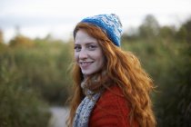 Ritratto di donna dai capelli rossi che guarda oltre la spalla la macchina fotografica — Foto stock