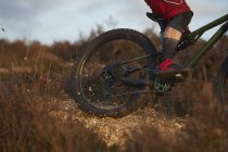Mountain biker wheel skidding on moorland gravel — Stock Photo
