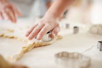 Руки дівчини і бабусі ріжуть великоднє печиво на кухонній стійці — стокове фото