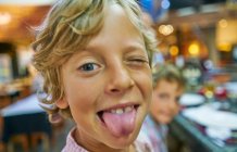 Retrato de menino olhando para a câmera, cutucando a língua — Fotografia de Stock