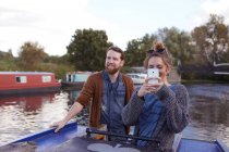 Пара фотографируется на лодке по каналу — стоковое фото