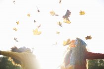 Dois amigos jogando folhas de outono no ar — Fotografia de Stock