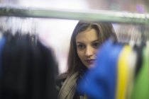 Young woman choosing clothes in shop — Stock Photo