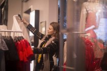 Seitenansicht einer jungen Frau beim Kleiderkauf — Stockfoto