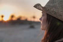 Portrait de femme portant un chapeau de paille détournant les yeux — Photo de stock