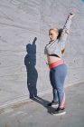 Kurvenreiche junge Frau trainiert und streckt die Arme aus — Stockfoto