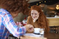 Two female friends relaxing in cafe — Stock Photo