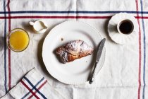 Vista dall'alto di croissant, caffè e succo di frutta sulla tovaglia — Foto stock