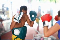 Mulher madura praticando boxe com treinador masculino no ginásio — Fotografia de Stock