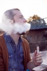 Man smoking electronic cigarette on canal boat — Stock Photo