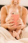 Baby girl and mother holding smartphone — Stock Photo