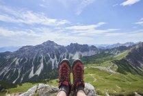 Perspectiva pessoal das botas de caminhada femininas sobre o vale nas montanhas de Tannheim, Tirol, Áustria — Fotografia de Stock