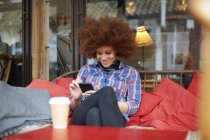 Женщина в кофейне с помощью мобильного телефона — стоковое фото