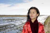 Retrato de jovem mulher asiática na praia em roupas tradicionais — Fotografia de Stock