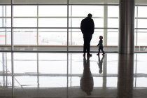 Padre e figlio accanto alla finestra dell'aeroporto, Alberta, Canada — Foto stock