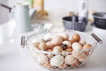 Basket full eggs on kitchen counter at easter — Stock Photo