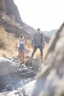 Young hiking couple walking over rocks in valley, Las Palmas, Canary Islands, Spain — Stock Photo