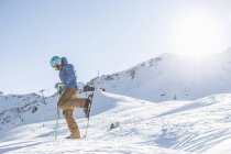 Männchen schnallt Skier auf schneebedecktem Berg an — Stockfoto