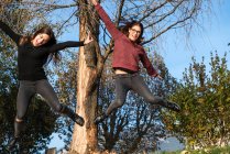 Две молодые женщины прыгают в лесу в воздухе — стоковое фото