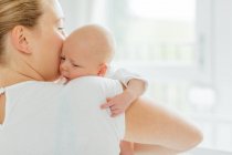 Joven mujer sosteniendo bebé hija - foto de stock