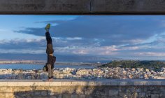 Man doing handstand on wall, Cagliari, Sardenha, Itália — Fotografia de Stock