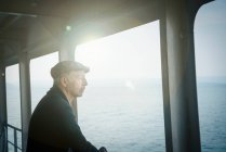 Man on ferry looking away out of window — Stock Photo