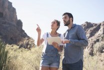 Jeune couple de randonneurs levant les yeux et pointant de la vallée, Las Palmas, Îles Canaries, Espagne — Photo de stock