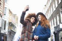 Due giovani donne che si fanno selfie in strada — Foto stock
