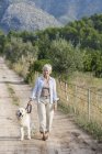 Portrait of senior woman walking pet dog — Stock Photo