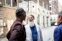 Трое взрослых мужчин на улице разговаривают — стоковое фото