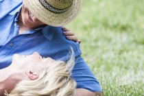 Cropped view of couple lying on grass — Stock Photo
