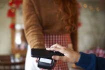 Kunde im Café macht kontaktloses Bezahlen mit Handy — Stockfoto