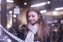 Young woman choosing clothes on shopping — Stock Photo