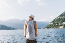 Вид сзади молодых мужчин, глядя на набережной озера Комо, Ломбардия, Италия — стоковое фото