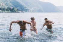 Tres jóvenes amigos se divierten en el lago Como, Como, Lombardía, Italia - foto de stock