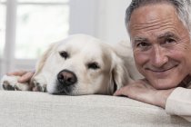 Portrait of man and golden retriever looking at camera — Stock Photo