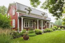 Фасад будинку дощата сосновий ліс з мансардного даху та ландшафтний сад, Квебек, Канада — стокове фото