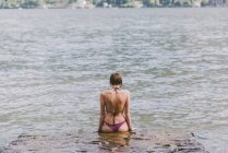Veduta posteriore di una giovane donna in bikini che guarda il Lago di Como, Lombardia, Italia — Foto stock