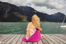 Rear view of woman sitting on pier looking away at view, Innsbruck, Tirol, Austria, Europe — Stock Photo