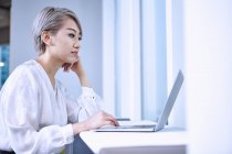 Side view of businesswoman using laptop — Stock Photo