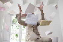 Businesswoman throwing paperwork in air — Stock Photo