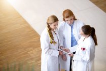 Tre medici di sesso femminile guardando tablet digitale — Foto stock